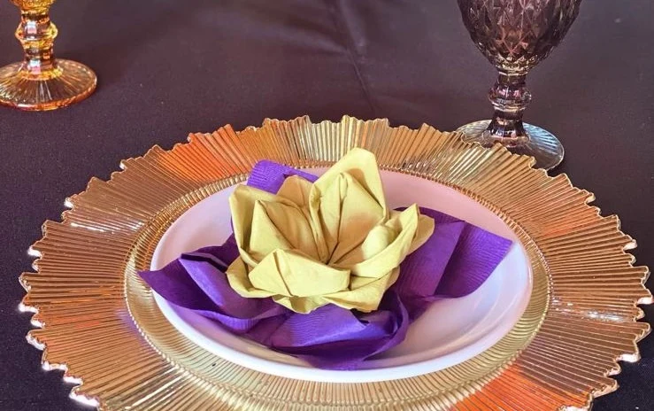 Detalle de plato de barro con servilleta artesanal doblada